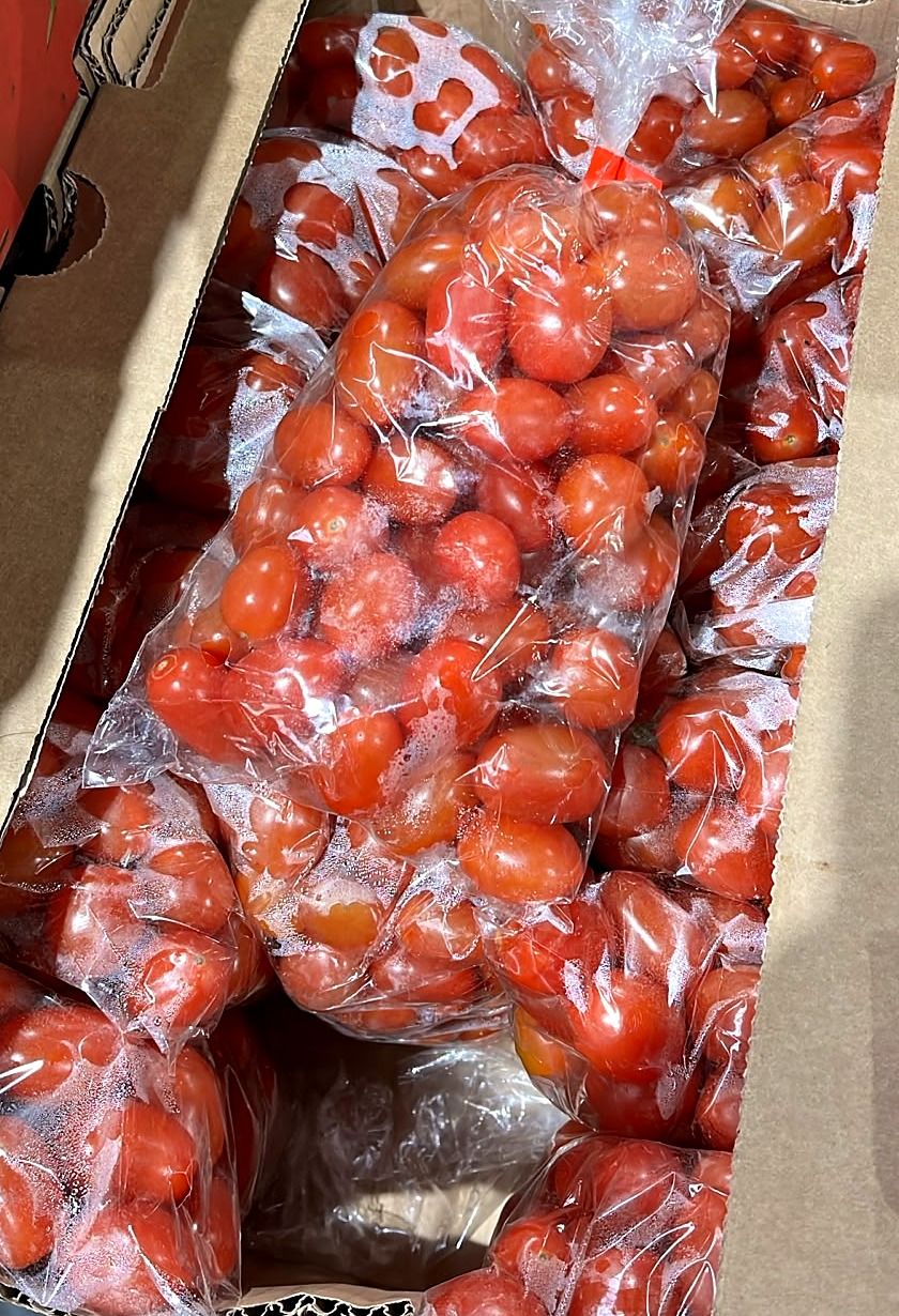 Bags of cherry and plum tomatoes in a box
